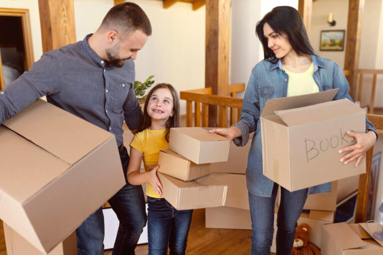 a family carrying boxes - Relocation vs Custom Home Build