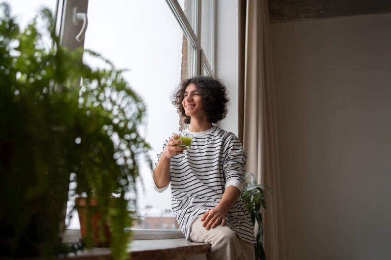 a woman having coffee while at her window - Owning vs Renting