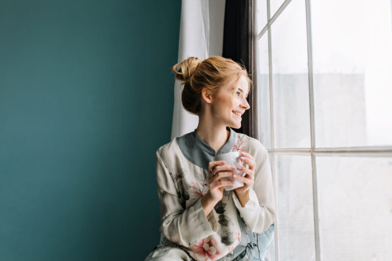 a woman enjoying her coffee while on her window - Owning vs Renting